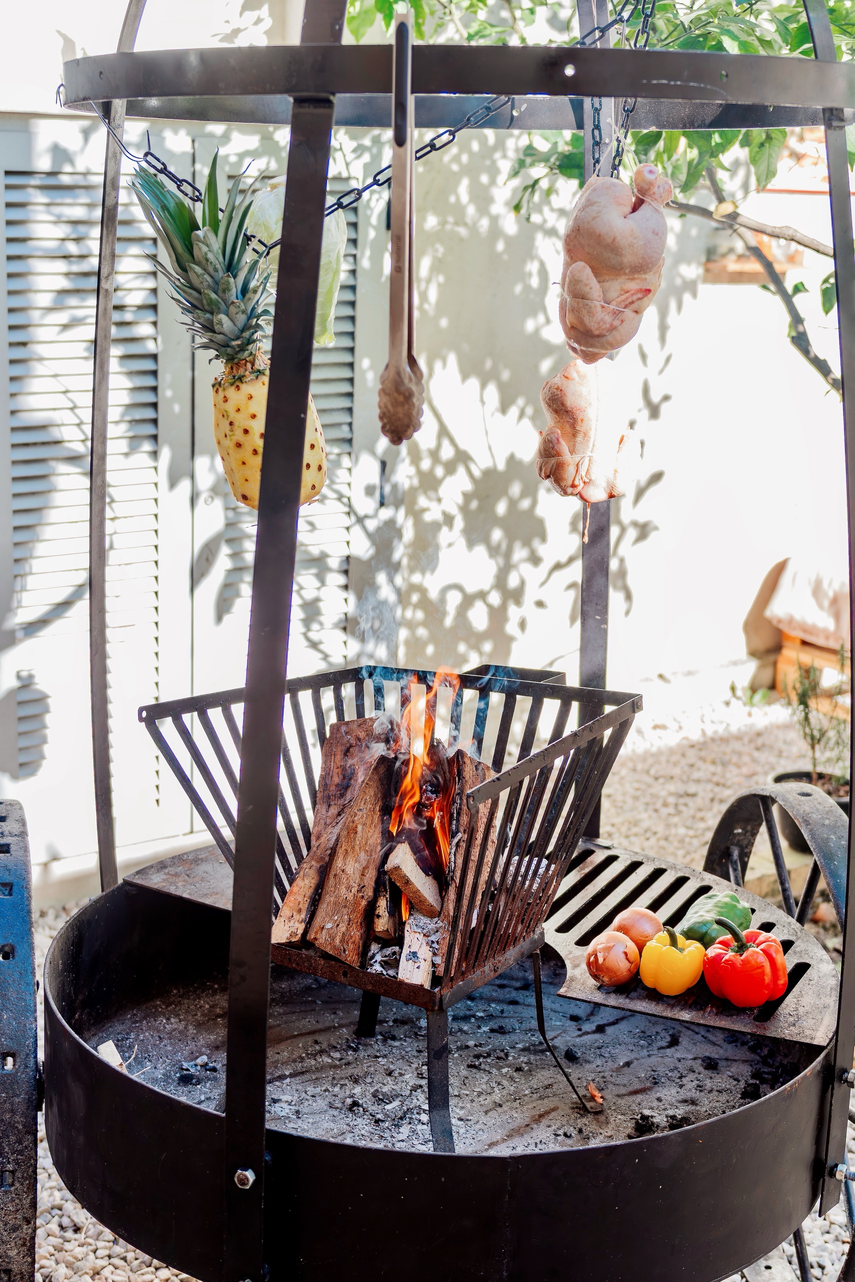 Fogonero ao vivo com carnes penduradas e fogo de lenha